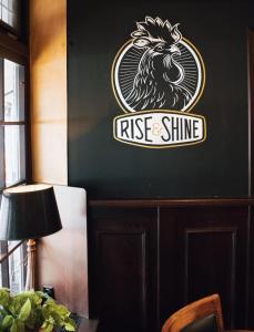 a wall with a rise and shine sign on it at Hotel Duhoux in Wirdum