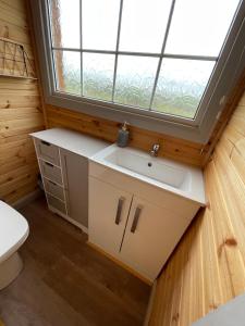 a bathroom with a sink and a window at Keepers Shepherd hut with Hot Tub in Whitby