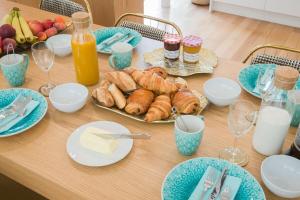 uma mesa com pratos de pastelaria e copos de leite em My Veranda em Paris