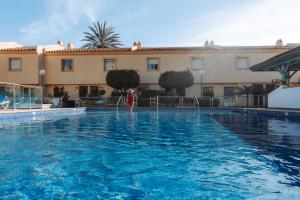 a person is standing in the water in a swimming pool at Ramada Hotel & Suites by Wyndham Costa del Sol in Fuengirola