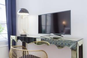 a desk with two chairs and a flat screen tv at My Veranda in Paris