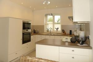 a kitchen with white cabinets and a counter top at Aurelia Haus 1 in Wyk auf Föhr