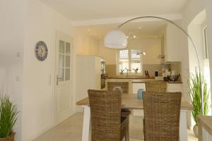 a kitchen with a table with chairs and a clock on the wall at Aurelia Haus 1 in Wyk auf Föhr