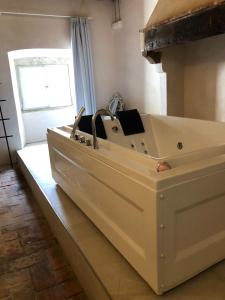 a large white bath tub in a room with a window at Allegra Toscana - Affittacamere Guest house in Arezzo