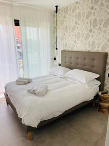 a bedroom with a large bed with white sheets and pillows at La Torre del Porto in Riccione