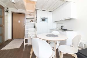 kuchnia i jadalnia ze stołem i krzesłami w obiekcie Apartamentai Malūno Vilos w Połądze