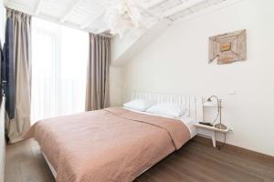 sypialnia z łóżkiem i dużym oknem w obiekcie Apartamentai Malūno Vilos w Połądze