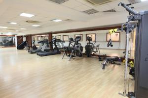 a gym with a bunch of treadmills and exercise bikes at Sandy Beach Hotel & Spa - ex Sentido in Larnaca