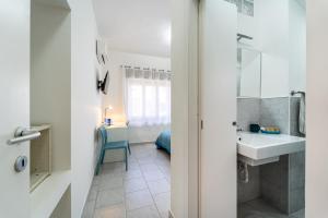 Trivano il Rifugio في كاربونيا: حمام مع حوض ومرآة