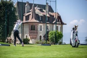 a person playing with a frisbee in front of a house at Le Manoir du Golf in Publier