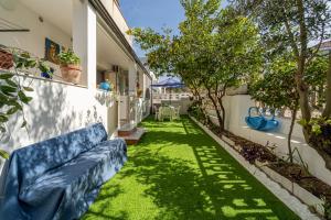 Trivano il Rifugio في كاربونيا: حديقة بها أريكة زرقاء في ساحة