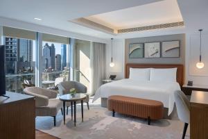 a hotel room with a bed and a large window at Kempinski Central Avenue Dubai in Dubai