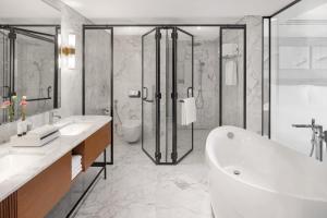 a bathroom with a tub and a sink and a shower at Kempinski Central Avenue Dubai in Dubai