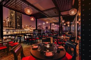 een restaurant met tafels en stoelen en een skyline van de stad bij Grand Millennium Business Bay in Dubai