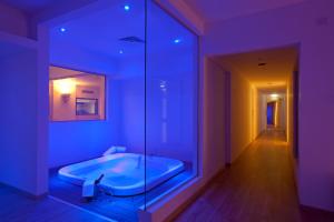 a bathroom with a tub with purple lighting at Sandy Beach Hotel & Spa - ex Sentido in Larnaca