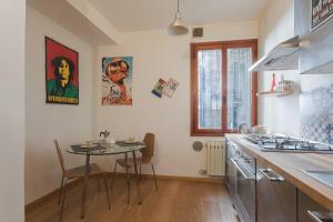uma cozinha com uma mesa e uma pequena mesa com cadeiras em San Lio Romantic X2 a Rialto em Veneza