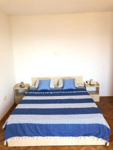 a bedroom with a blue and white bed with blue pillows at Apartment Bella Costa in Rijeka