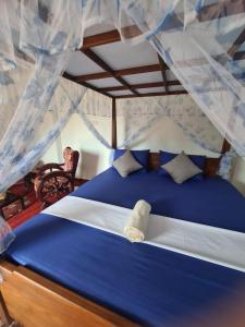 a bedroom with a blue bed with a canopy at SILVER RAIL in Galle