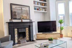 a living room with a fireplace and a flat screen tv at Townhouse Apartment Carlisle in Carlisle