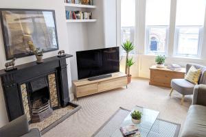 a living room with a fireplace and a television at Townhouse Apartment Carlisle in Carlisle +22 photos
