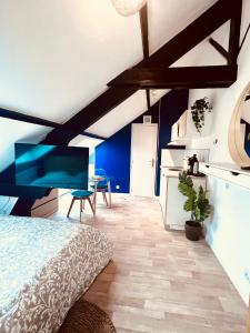 a bedroom with a bed and a blue wall at Les studios de la Villa Jules Verne in Amiens