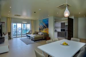 uma sala de estar com uma mesa branca e um sofá em Aura Suites em Dar es Salaam