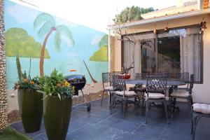 a patio with a table and chairs and a mural at PH in Atlantic Coast in Charneca