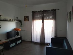 a living room with a tv and a window at Fiera&Aeroporto House in Fiumicino