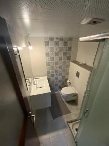 La salle de bains est pourvue de toilettes blanches et d'un lavabo. dans l'établissement Bethlehem-the-Wall Apartment, à Bethléem