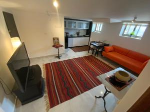 un salon avec un canapé orange et une télévision dans l'établissement Bethlehem-the-Wall Apartment, à Bethléem