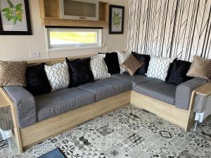 a large couch in a living room with a window at Chapel Fields Holiday Park in Chapel Saint Leonards