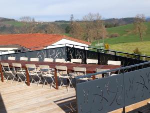 een balkon met stoelen en een tafel op een terras bij gîte de l'atelier 15 personnes in Grazac