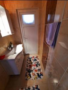 a bathroom with a door and a rug in front of a shower at MY HOME in Beysehir