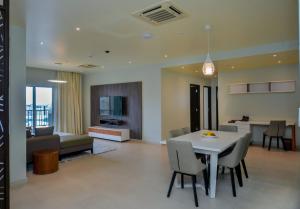 a dining room and living room with a table and chairs at Aura Suites in Dar es Salaam