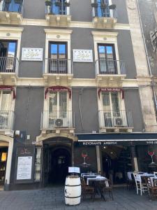 un edificio con tavoli e sedie di fronte di Etna Rosso b&b a Catania