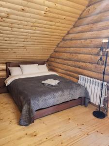1 dormitorio con 1 cama en una cabaña de madera en БЕРЕЗИНИ, 