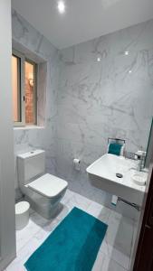 a white bathroom with a toilet and a sink at Flat in Valletta in Valletta
