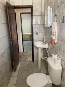 a bathroom with a toilet and a sink at Apartamento Inteiro Central 2 Quartos e Kitnet Inteira 01 quarto in Ponta Grossa