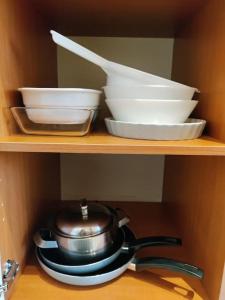 a shelf with bowls and a tea pot and plates at Toimiva kodikas yksiö in Heinola