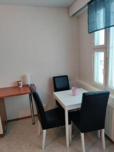 a room with a table and two chairs and a desk at Toimiva kodikas yksiö in Heinola