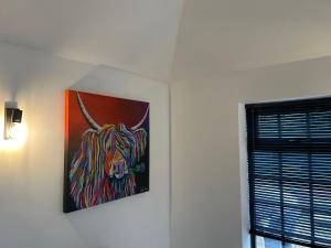 a painting of a bull hanging on a wall at The Old Stables in Mews in Kessingland