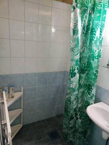a bathroom with a shower curtain with a sink at Toimiva kodikas yksiö in Heinola