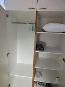 a closet with white shelves and a white pillow at Toimiva kodikas yksiö in Heinola
