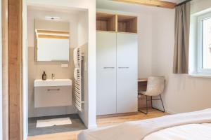 a bedroom with a bathroom with a sink and a mirror at Apartment Eden Großbichl 