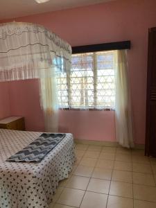 a bedroom with a bed and a large window at ZURI Homestay WIFI & Ocean BREEZE !! in Mombasa