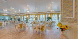 un comedor con mesas, sillas y flores en Mena Palace Hotel - All Inclusive, en Sunny Beach