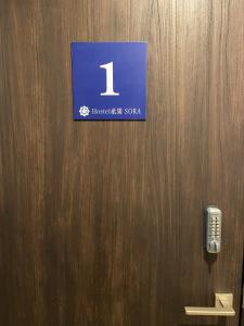 京都的住宿－Higashi Shimbashi Building 3F Hostel Gion SORA - Vacation STAY 92728v，木门,上面有标志,有电话