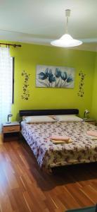 a bedroom with a bed and a green wall at Apartman Jadranka in Veli Lošinj