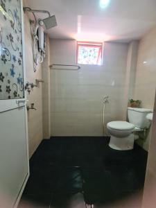 een kleine badkamer met een toilet en een raam bij SILVER RAIL in Galle