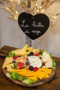 um bolo com queijo e fruta na mesa em Les alouettes em Caudry